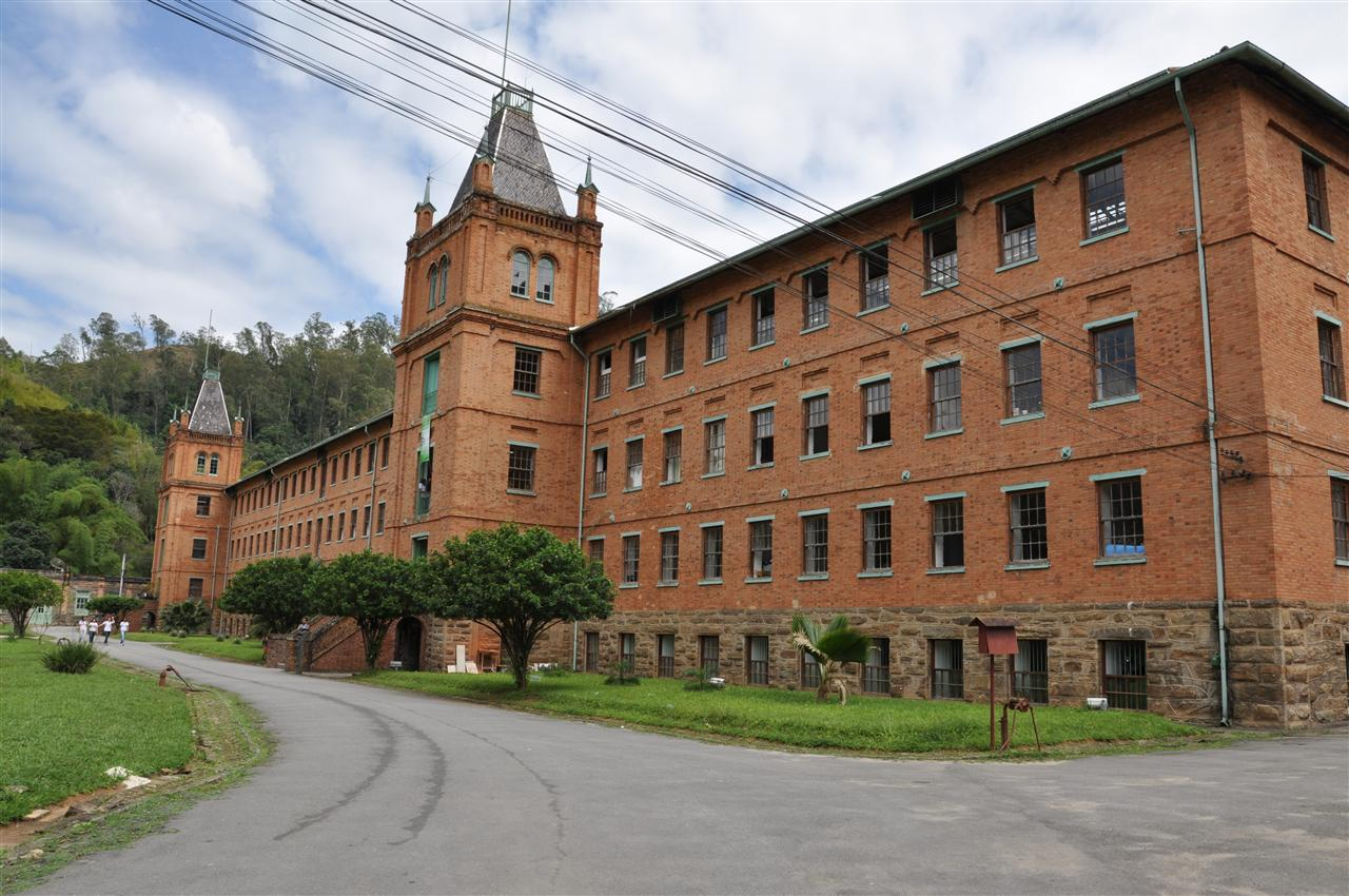 Edifício Histórico de Tijolos com Torres em Paisagem Verde