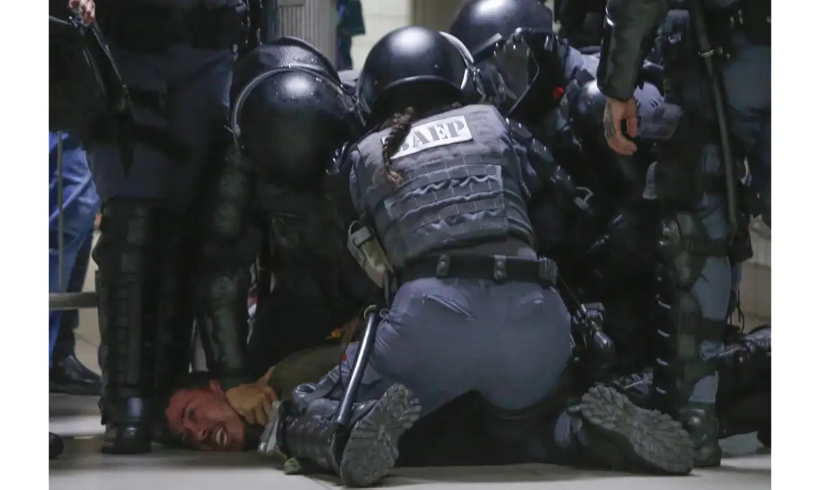 Ação Policial: Imobilização Forçada de Indivíduo por Agentes