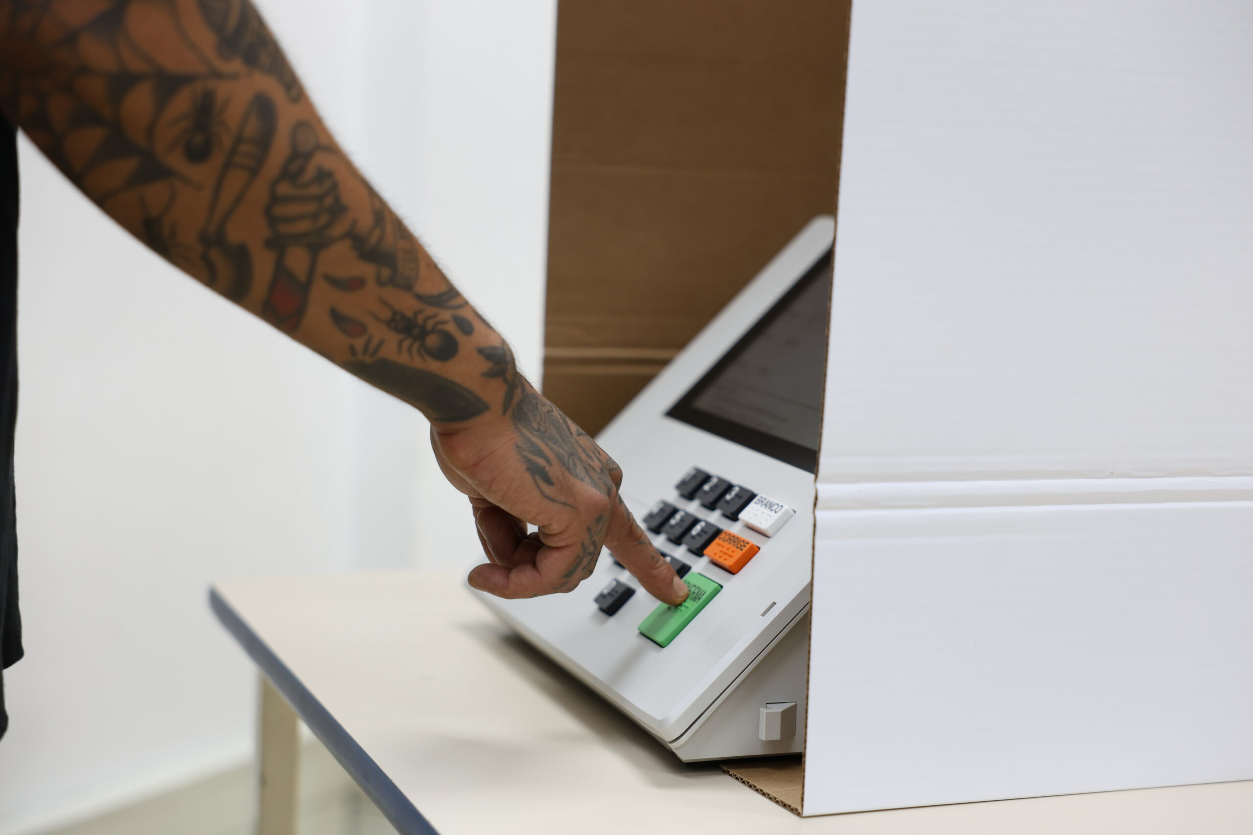 Eleitor com Mão Tatuada Votando na Urna Eletrônica Brasileira