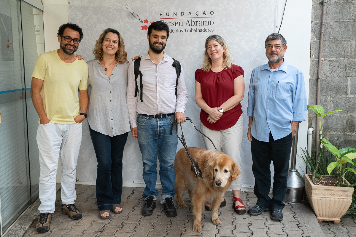 Grupo diverso com cão-guia na Fundação Perseu Abramo