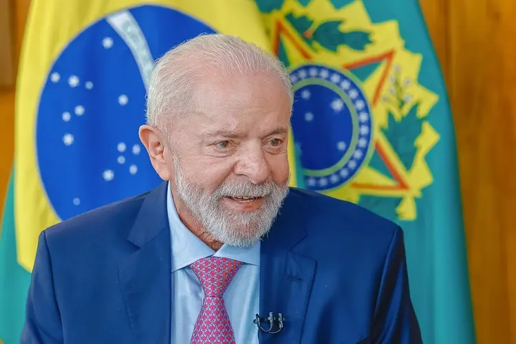 Presidente Lula Sorrindo em Evento Oficial com Bandeiras do Brasil