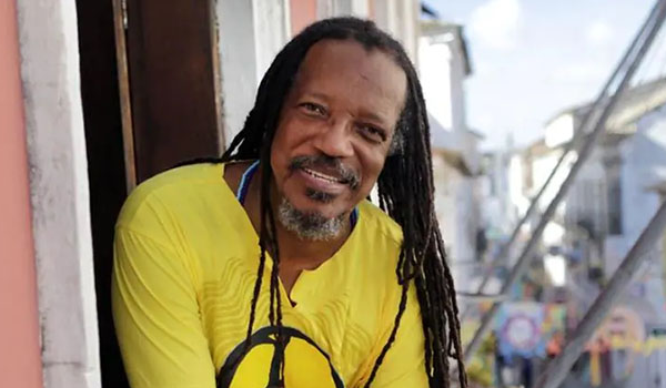 Homem Negro Sorridente de Dreadlocks com Símbolo da Paz