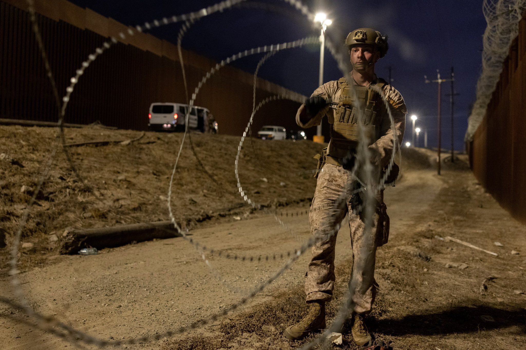 Vigilância Noturna: Soldado na Fronteira com Arame Farpado