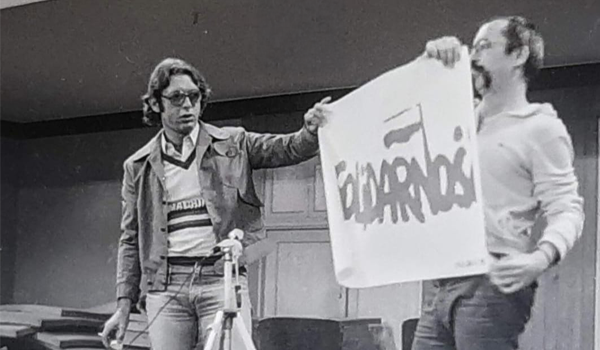 Ativistas exibem cartaz Solidarność em palco