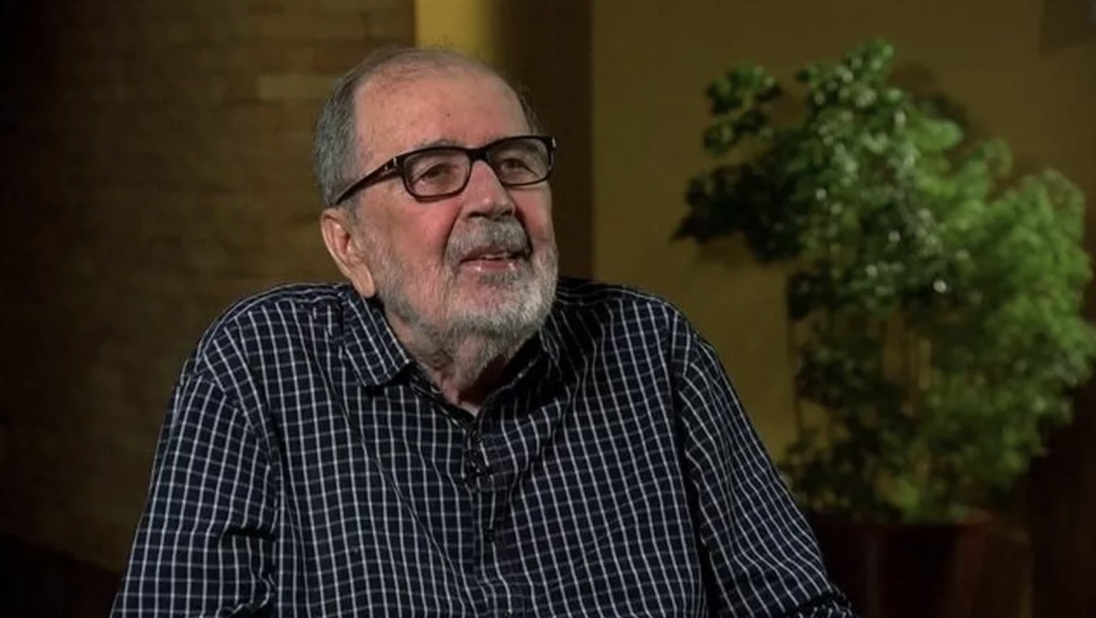 Retrato de homem idoso com óculos e barba.