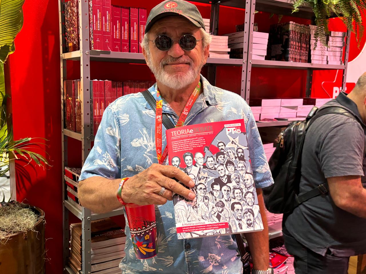 Homem sorridente com revista Teoria&Debate Edição Especial PT45