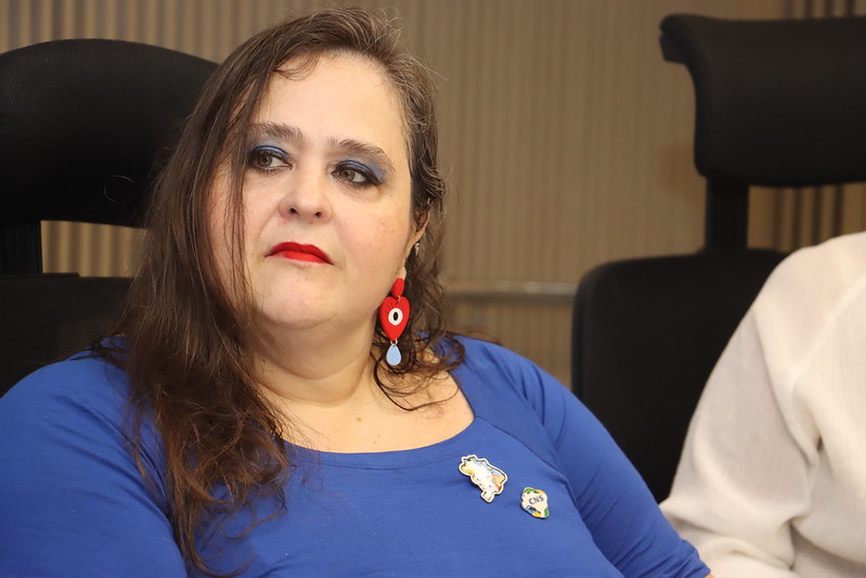 Mulher em Azul com Pins: Reflexão e Engajamento Político