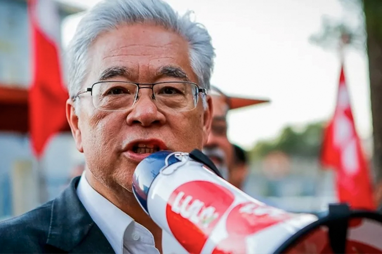 Ativista com megafone "LULA" em manifestação.