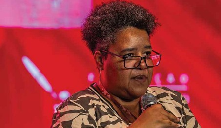 Mulher Negra Palestrante com Microfone em Evento