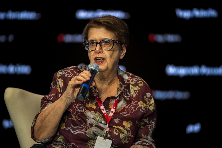 Mulher palestrando em evento público com microfone