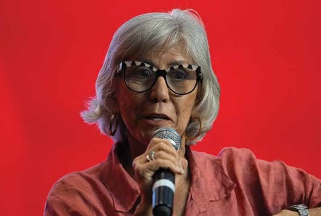 Mulher líder política discursando em fundo vermelho