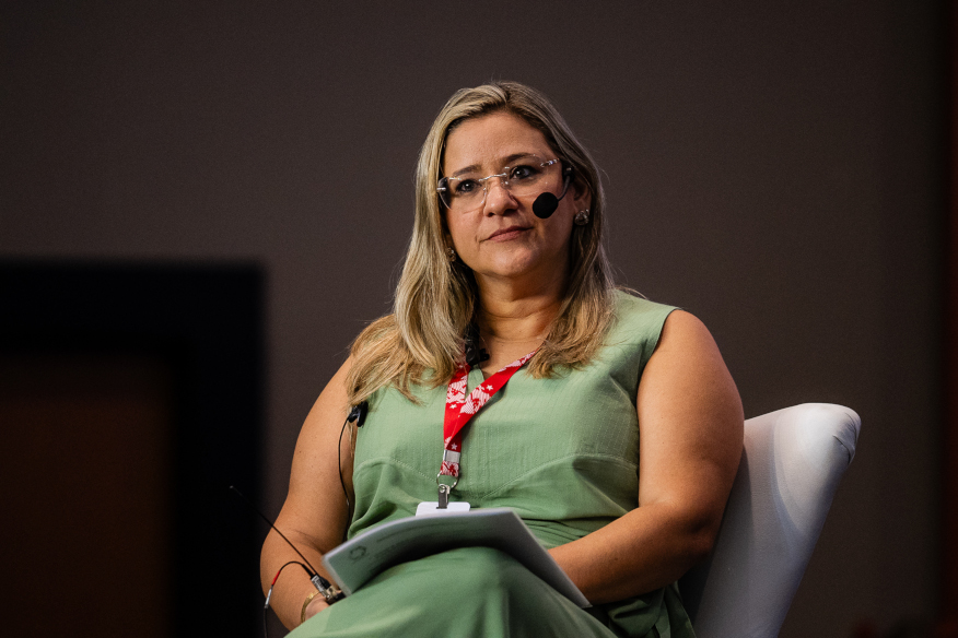 Mulher palestrante em evento: foco e reflexão
