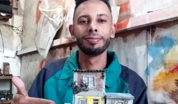 Homem exibe maquete detalhada de casa de favela