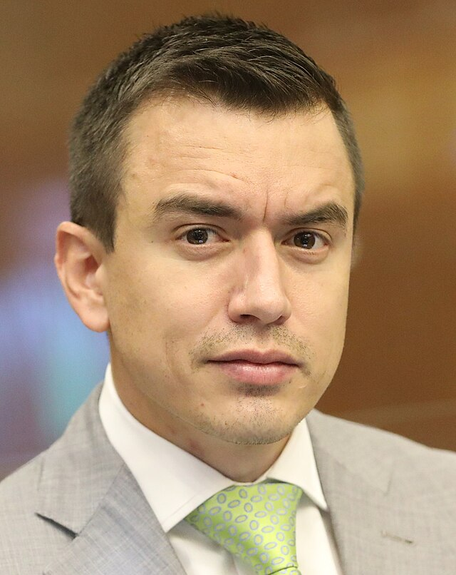 Homem sério em terno, olhar direto e concentrado.