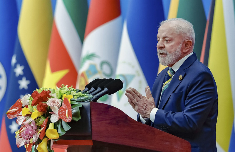 Lula discursa em evento internacional com bandeiras