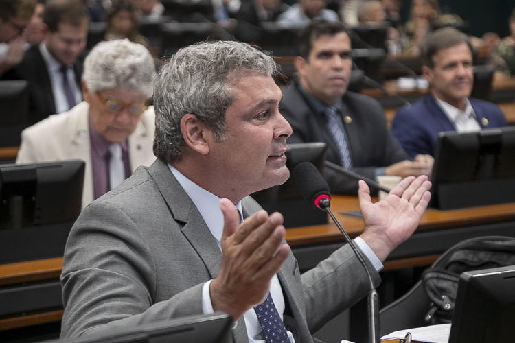 Homem discursa com entusiasmo em sessão legislativa