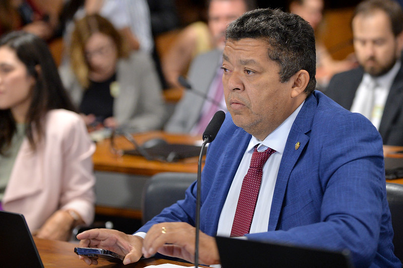 Homem em terno azul discursando em evento político