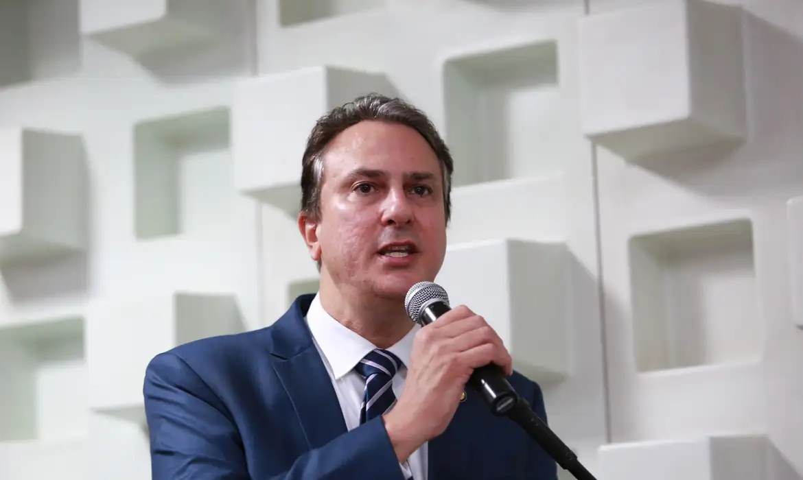 Líder político em discurso público com microfone.