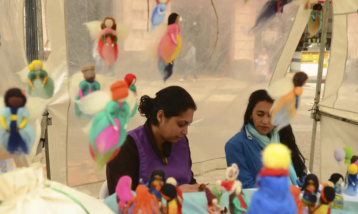 Artesãs e bonecas artesanais em feira cultural