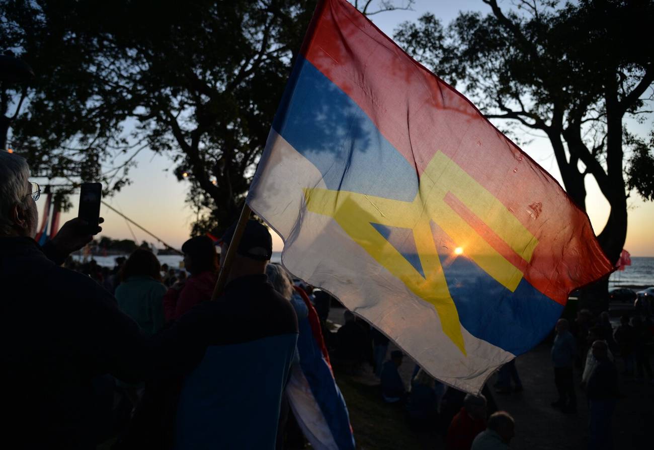 Multidão com Bandeira ao Pôr do Sol: Mobilização e Esperança