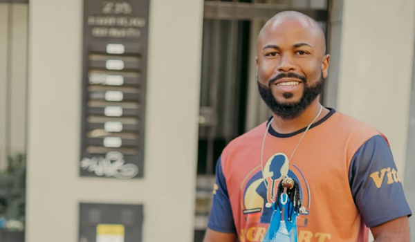 Jovem negro sorridente com camiseta estampada e colar