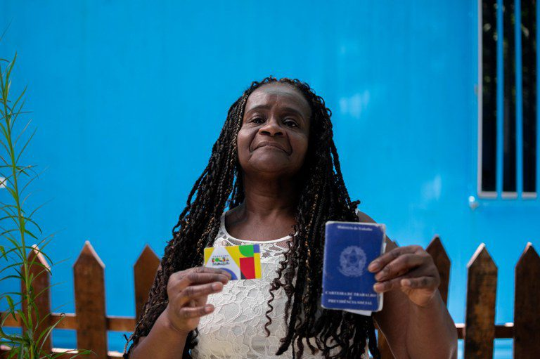 Dignidade e Direitos: Mulher Negra Exibe Carteira de Trabalho e Cartão Social