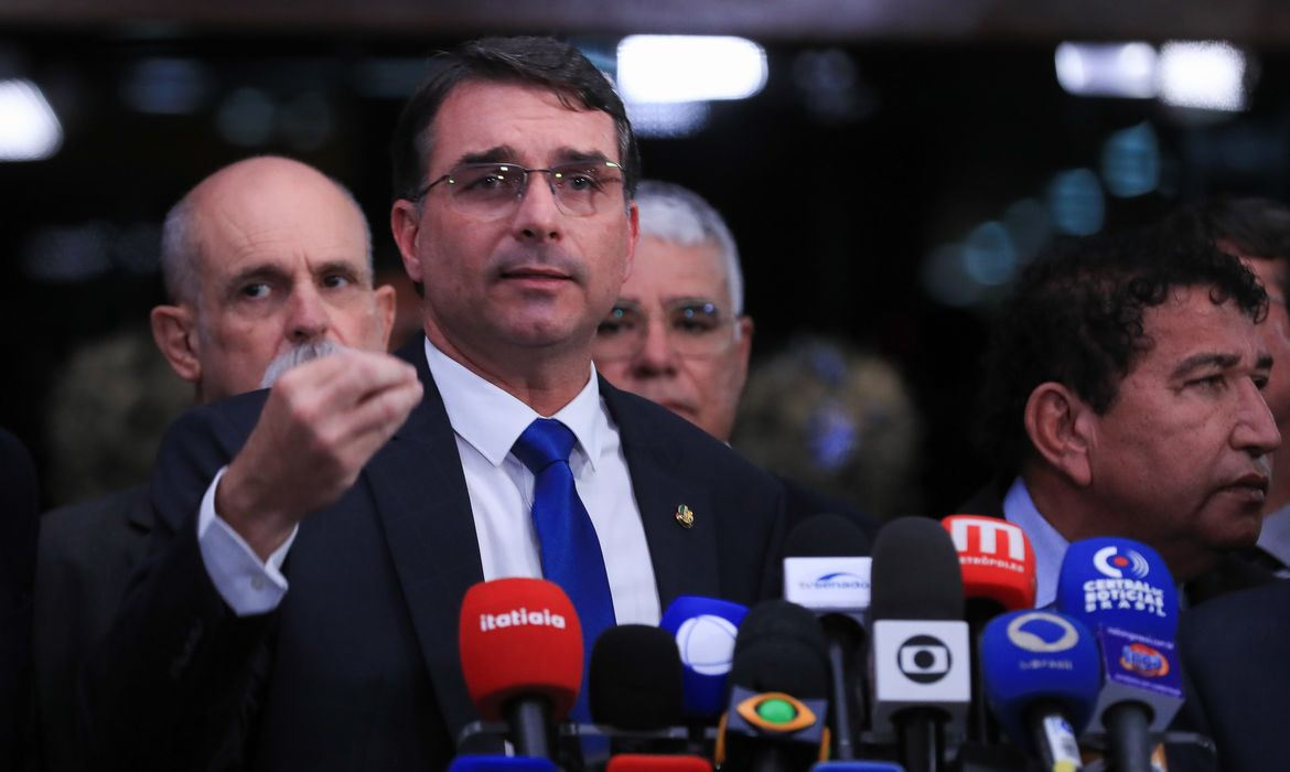 Político brasileiro em coletiva de imprensa com múltiplos microfones