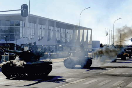 Desfile militar de tanques em frente a edifício governamental