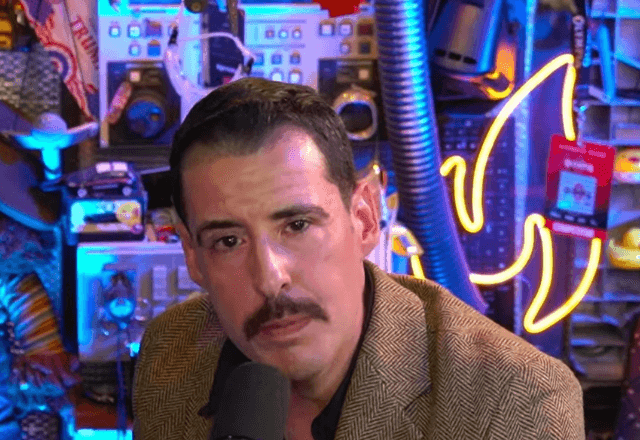 Analista com bigode em podcast político.